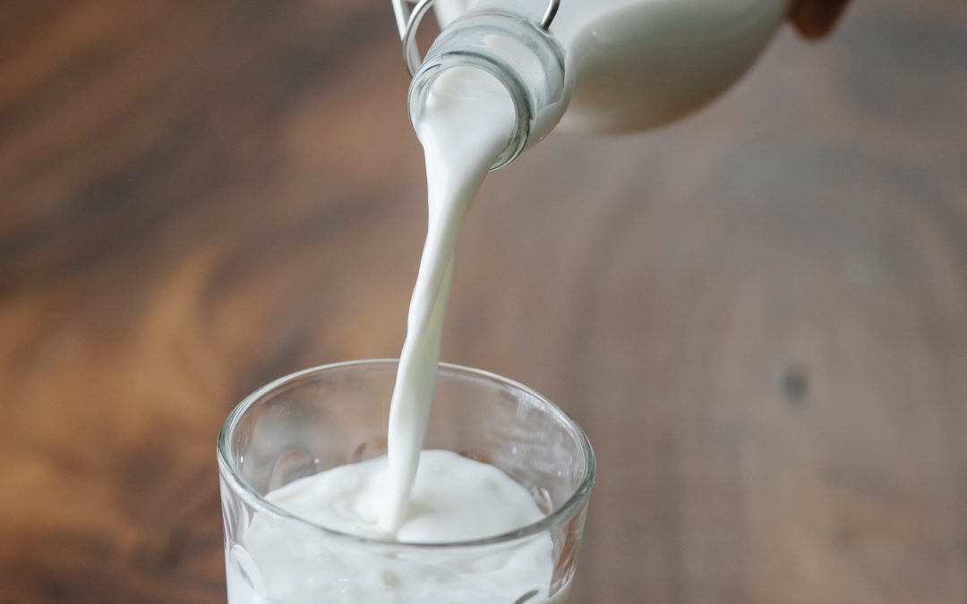 Milk being poured from a bottle to a glass
